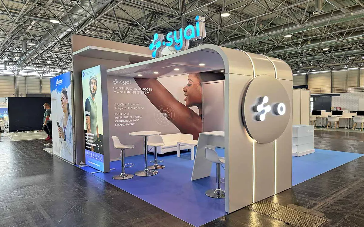 Stand modular de Syai Health Technology con gráfica de marca y zonas de reuniones