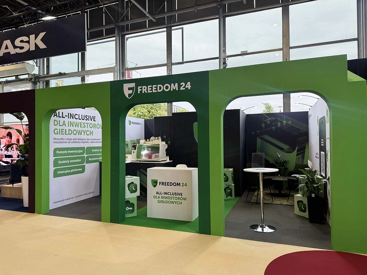 Stand modular con un frente abierto, paredes gráficas de marca y zona de presentación funcional