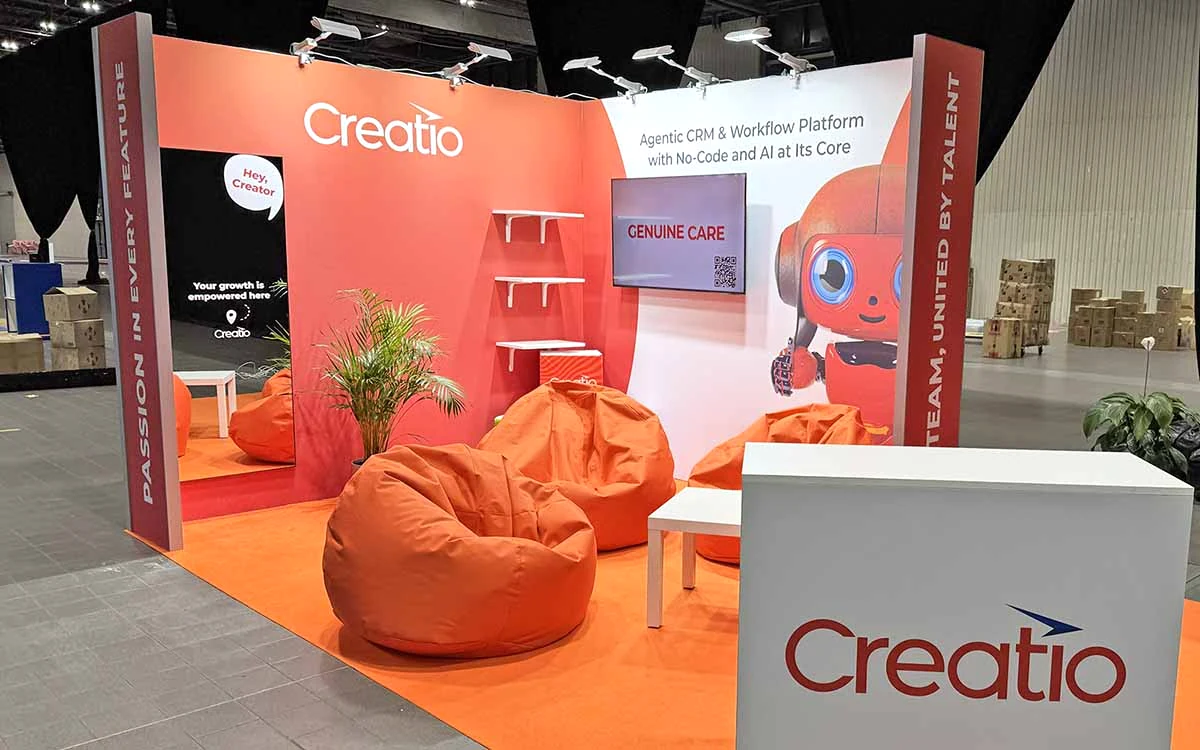 Stand modular de Creatio para ferias, con paredes gráficas personalizadas y zona de reuniones